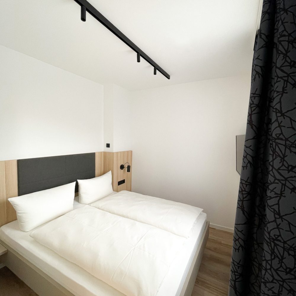 Blick auf das Doppelbett im Apartment Familienzimmer im Holi City Apart Hotel Berlin